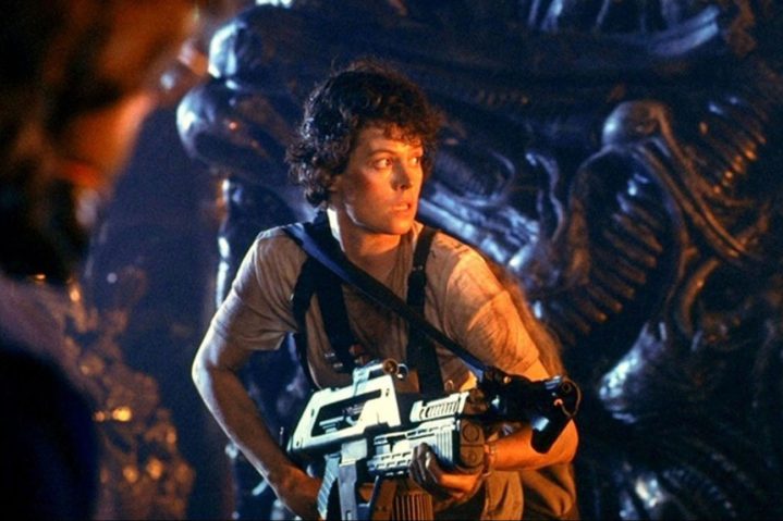 Ellen Ripley, gun in hand, bracing herself for a Xenomorph ambush in Aliens.