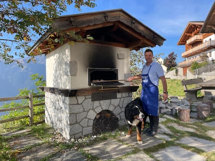 Josef Gamper von der Taser-Alm – hier mit Berner Sennhund Motti – backt sein Brot im Holzofen.