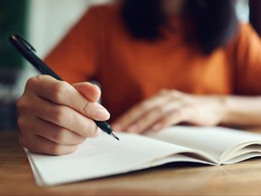 Close up woman hand writing on notebook .