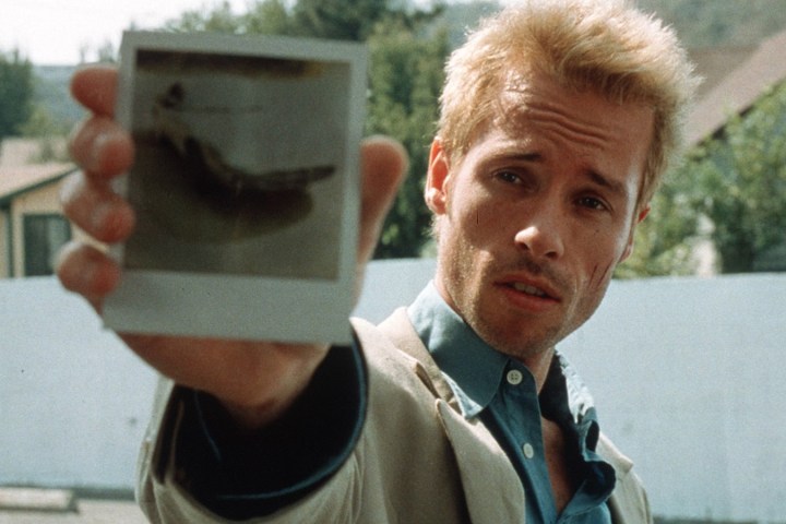 Guy Pearce as Leonard Shelby showing a polaroid to the camera in Memento.