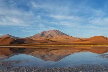 Blick auf eine Dünenlandschaft in der Atacama Wüste in Chile, davor ein Wüstensee