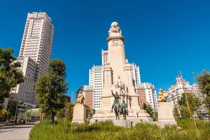 Das Cervantes-Denkmal zeigt unter anderem die Figuren Don Quijote und seinen Begleiter Sancho Panza (rechts). Hinter dem Brunnen erhebt sich das Edificio España.