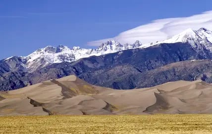 Blick auf die Sanddünen vor der Berglandschaft der Rocky Mountains im Great Sand Dunes National Park in den USA