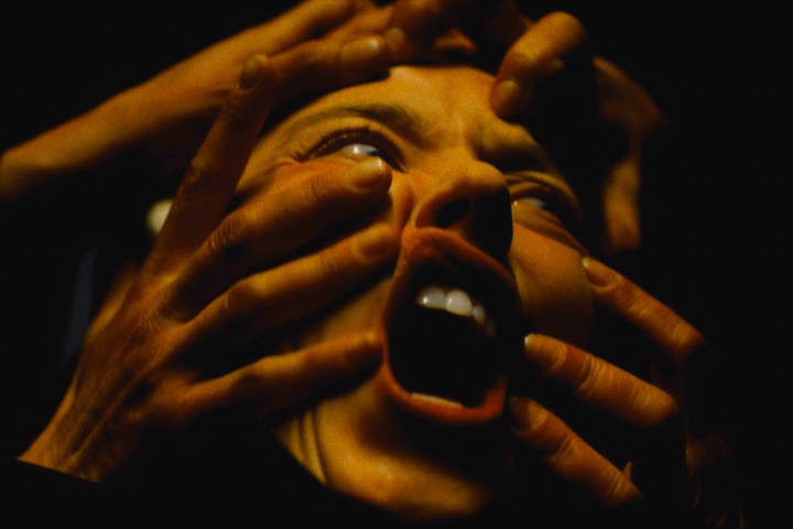 Hands grab at Sydney Sweeney's screaming face in Immaculate.