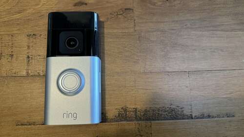 The Ring Battery Doorbell Pro on a wooden background.