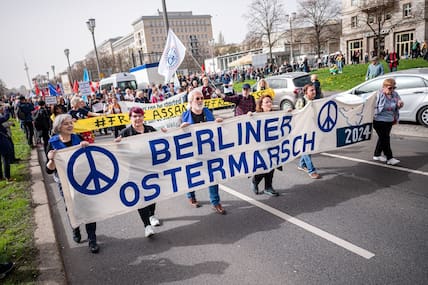 Menschen nehmen an dem traditionellen Ostermarsch unter dem Motto «Kriegstüchtig - Nie wieder» mit einem Banner mit der Aufschrift „Berliner Ostermarsch 2024“ teil.