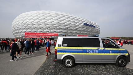 Ein Fahrzeug der Polizei steht vor dem Eingang der Allianz Arena.