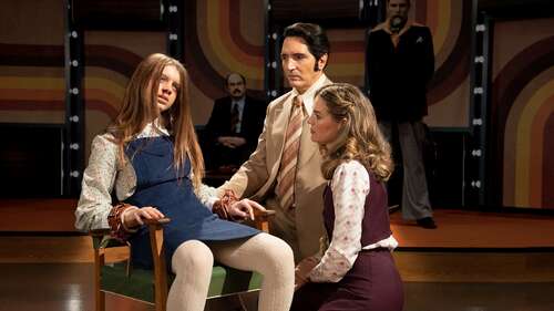 David Dastmalchian and Laura Gordon speak to a possessed Ingrid Torelli on the set of a talk show in a still from Late Night with the Devil