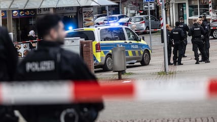 Einsatzkräfte stehen im abgesperrten Bereich in der Innenstadt Bochums.