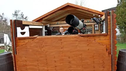 Christian Klemkow schaut aus der Sternwarte. Dazu hat er das Dach geöffnet.