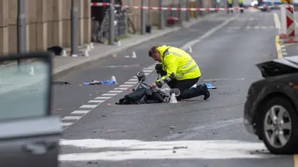 Ein Polizist kniet an einer Unfallstelle in der Leipziger Straße an einem Kinderwagen. Bei schweren Unfällen in Berlin-Mitte sind sechs Menschen schwer verletzt worden.