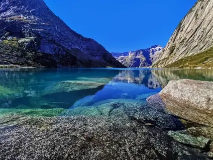 Türkisblauer See in Berglandschaft.