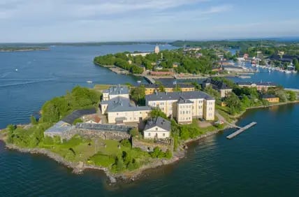 Blick von oben auf die Insel Suomenlinna mit ihren Museumsgebäuden und grüne Nachbarinseln in der Ostsee