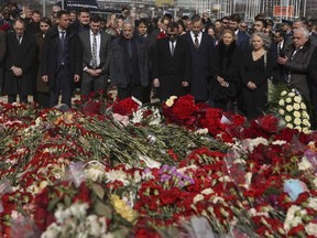 A group of ambassadors of foreign diplomatic missions attend a laying ceremony at a makeshift memorial in front of the Crocus City Hall on the western outskirts of Moscow, Russia, Saturday, March 30, 2024.