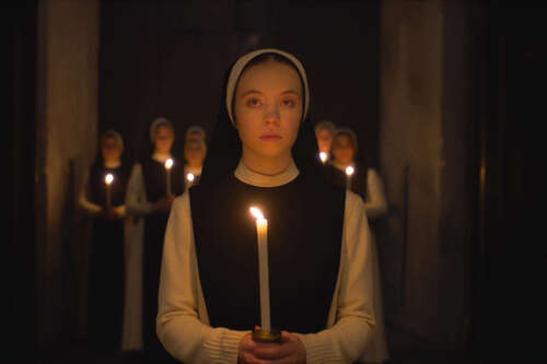 Sydney Sweeney holds a candle in Immaculate.