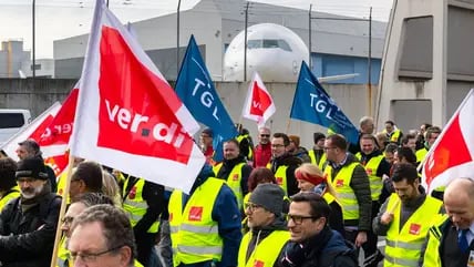 Ein Protestzug von Streikenden zieht mit Bannern und Verdi-Fahnen vom Lufthansa Aviation Center zum Terminal 1.