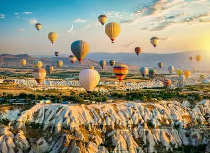 Zahlreiche Heißtluftballons schweben am Himmel über Kappadokien.