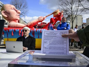 A protestor feeds an election ballot in to a shredder