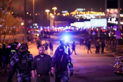 Soldaten der russischen Nationalgarde (Rosgwardija) helfen einem Mann, einen Bereich in der Nähe des Crocus City Hall am westlichen Rand von Moskau zu verlassen. 