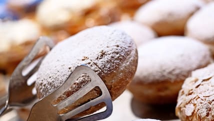  Verschiedene Berliner liegen in einer Bäckerei in der Auslage. 