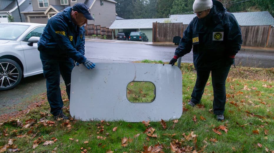 Two investigators examine a plane door