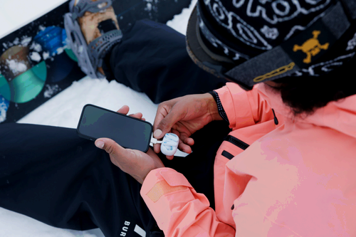 Earbuds plugging into a smartphone to charge.