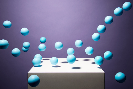 Blue balls bouncing off of white cube