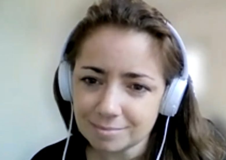 Woman with long, brown hair wearing over-the-ear headphones on Zoom.