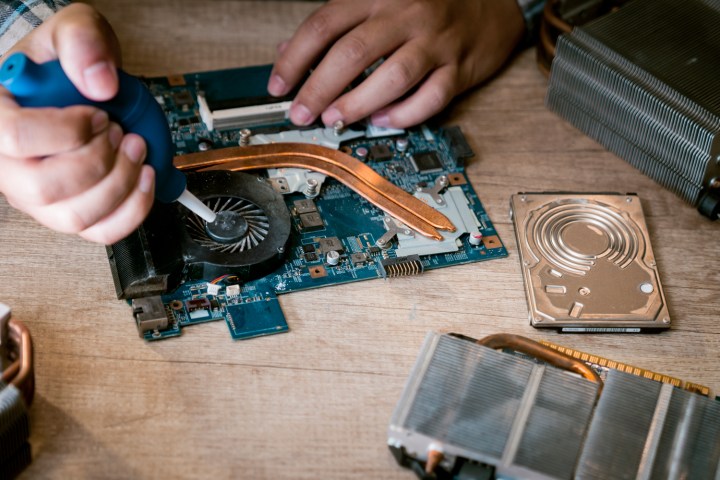 Cleaning a laptop fan with air blower.