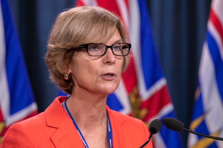 A white woman with short brown hair addresses a news conference.