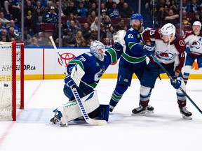 Colorado Avalanche's Nathan MacKinnon, not seen, scores on Vancouver Canucks goaltender Casey DeSmith (29) as Ian Cole (82) and Colorado's Valeri Nichushkin (13) watch during NHL overtime action in Vancouver on Wednesday.