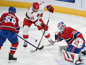 Carolina Hurricanes' Stefan Noesen (23) moves in on Canadiens goaltender Sam Montembeault as Canadiens' David Savard (58) defends in Montreal on Saturday, March 30, 2024.