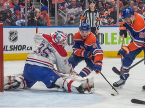 Connor McDavid reaches for the [puck in front of the Canadiens net