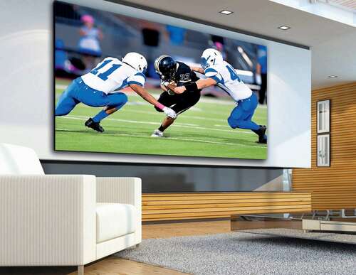 A huge wall-sized TV shows a football game.