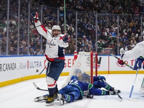 Washington Capitals' Alex Ovechkin, front left, celebrates his goal as Vancouver Canucks' Pius Suter, bottom centre, and Filip Hronek, back, lie on the ice during second period NHL hockey action in Vancouver, B.C., Saturday, March 16, 2024.