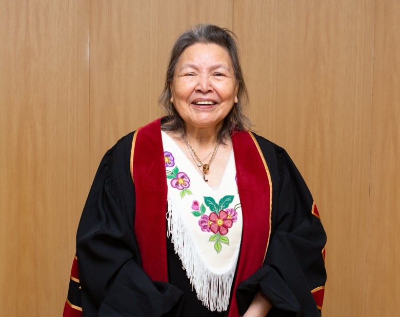 Beaming woman in ceremonial dress.