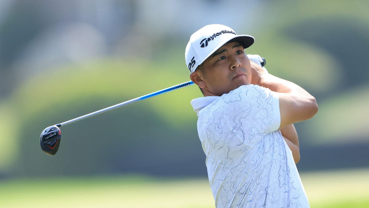 Kurt Kitayama wearing a cap, swinging a golf club over his shoulder.