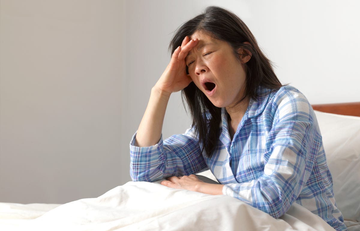 Woman yawning because she is waking up tired.