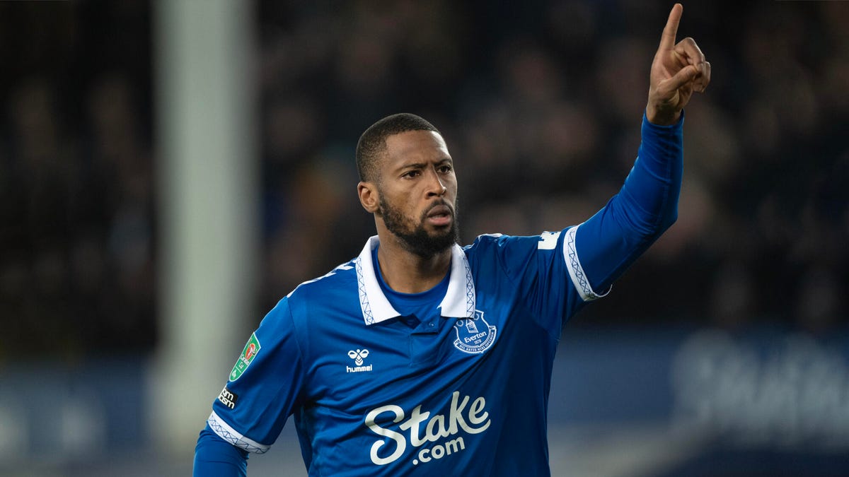 Everton striker Beto celebrating, pointing upwards with his left hand.