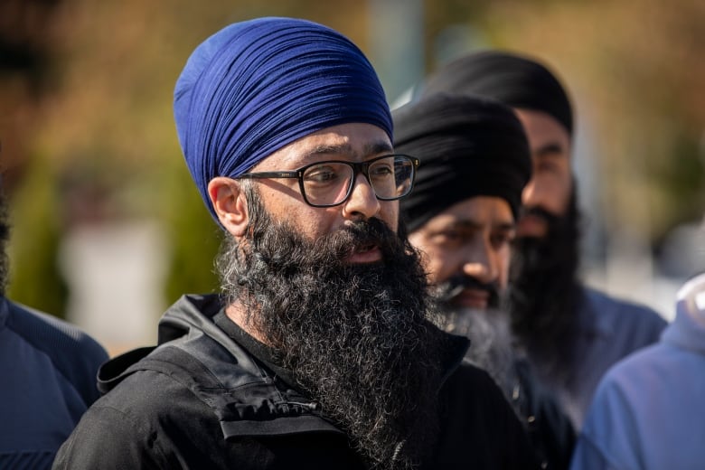 A Sikh man with a blue turban speaks.