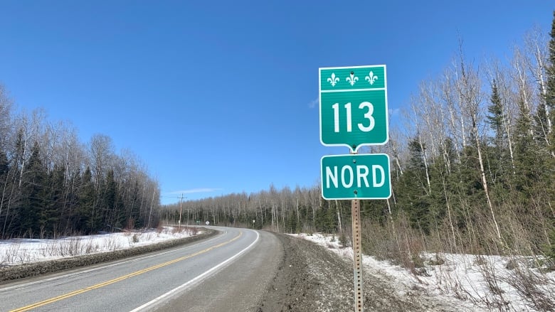 a sign with a highway in the background