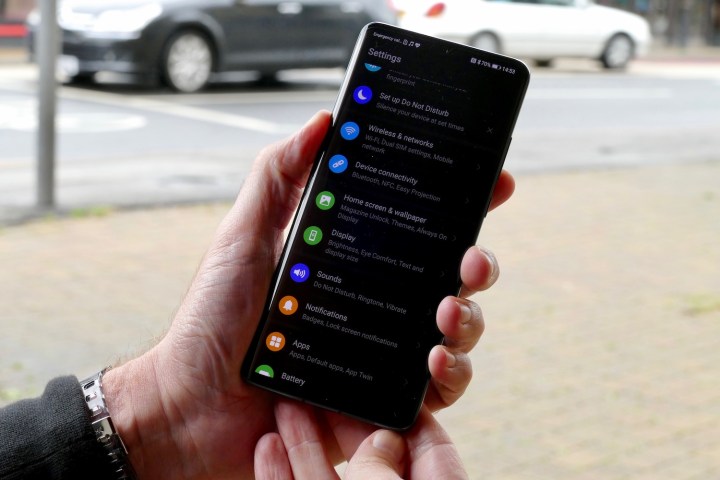 Person holding Huawei EMUI 10 in Dark Mode.