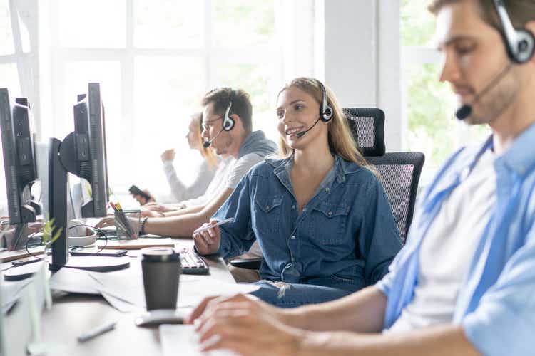 Young handsome male customer support phone operator with headset working in call center