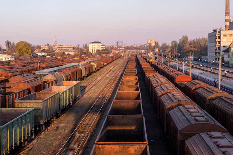 Train station in autumn, many rusted empty wagons.