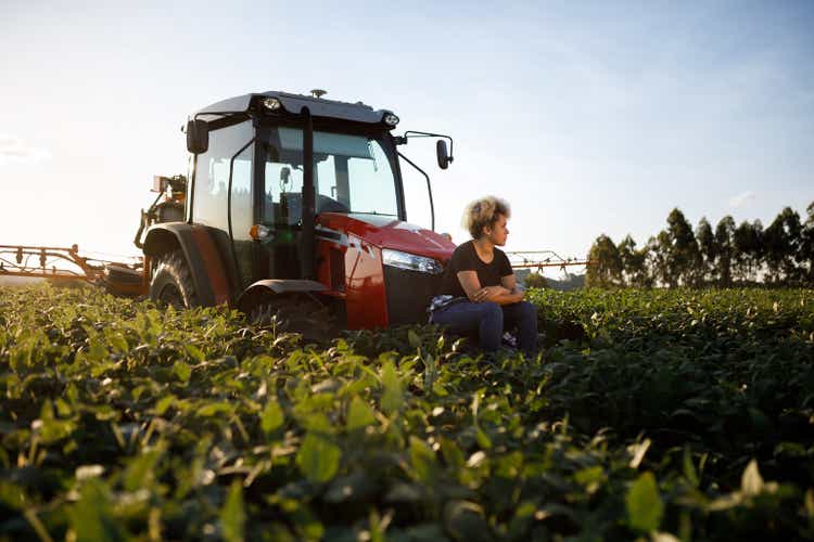 Afro-brazilian woman sitting outside a combine in the field