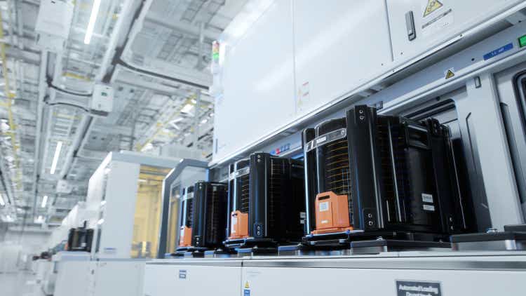 Row of Wafer FOUPs Inside Bright Advanced Semiconductor Production Fab Cleanroom with Working Overhead Wafer Transfer System