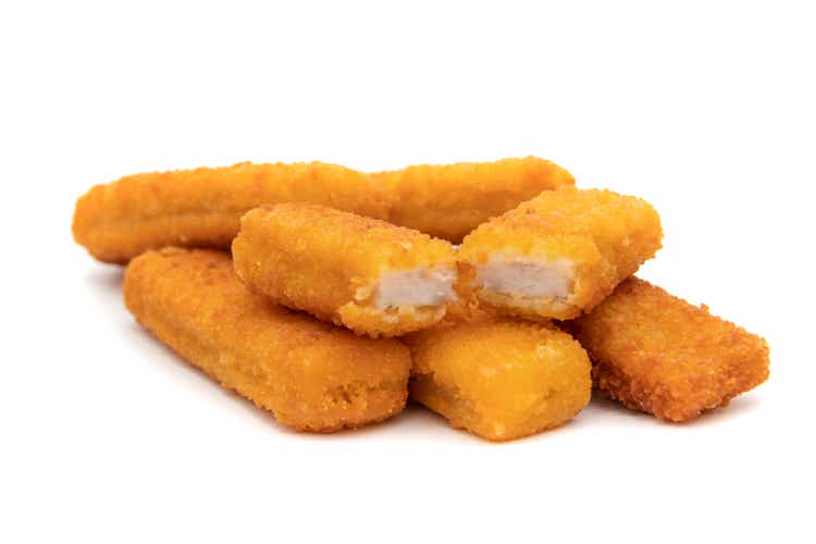 Tasty crispy fried fish sticks (fish fingers) on white background.