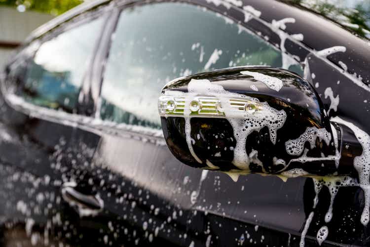 Outdoor car wash. Gentle Car Washing. Modern Car Covered by soap and Water. automobile, auto wash foam water,Auto detailing or valeting concept. Selective focus.