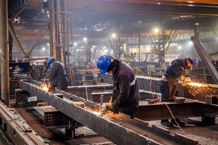 Metal workers using a grinder