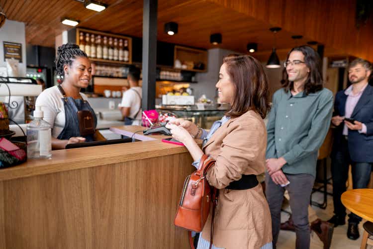 Businesswoman paying her bill at coffee shop checkout